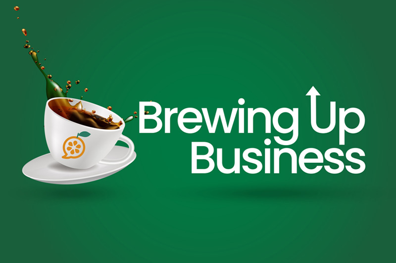 A graphic with the slogan "Brewing Up Business" on a green background. It features a white coffee cup on a saucer with a dynamic splash of coffee spilling out, and coffee beans flying out as well. The cup has an orange fruit symbol on it, suggesting a blend of coffee and fresh ideas or business growth.