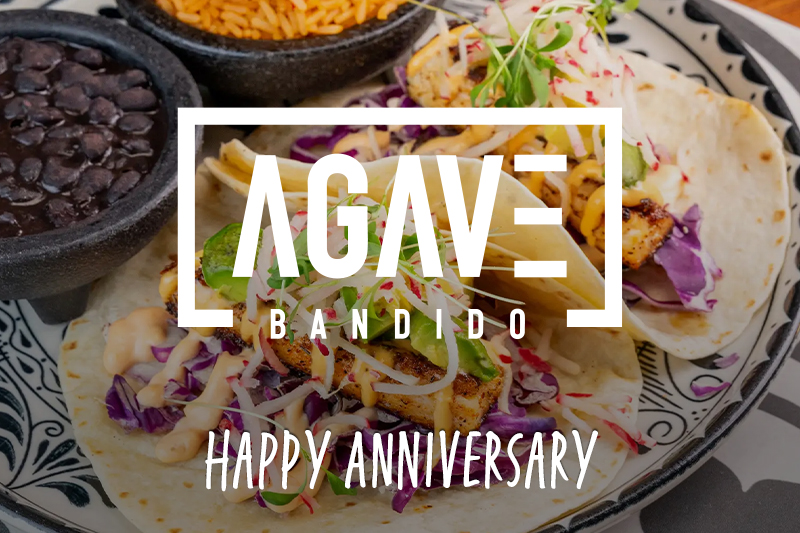 Agave Bandido — Happy Anniversary. Promotional graphic featuring a close-up of fish tacos on a decorative plate, with sides of black beans and Spanish rice in the background.